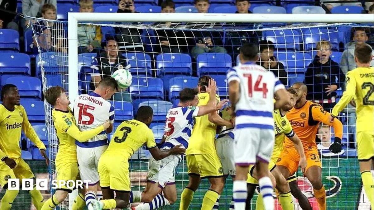 Players contesting a header in front of goal