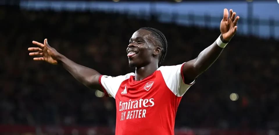 Futbolchi g'alaba qozonganida qo'llarini ko'tarib turibdi