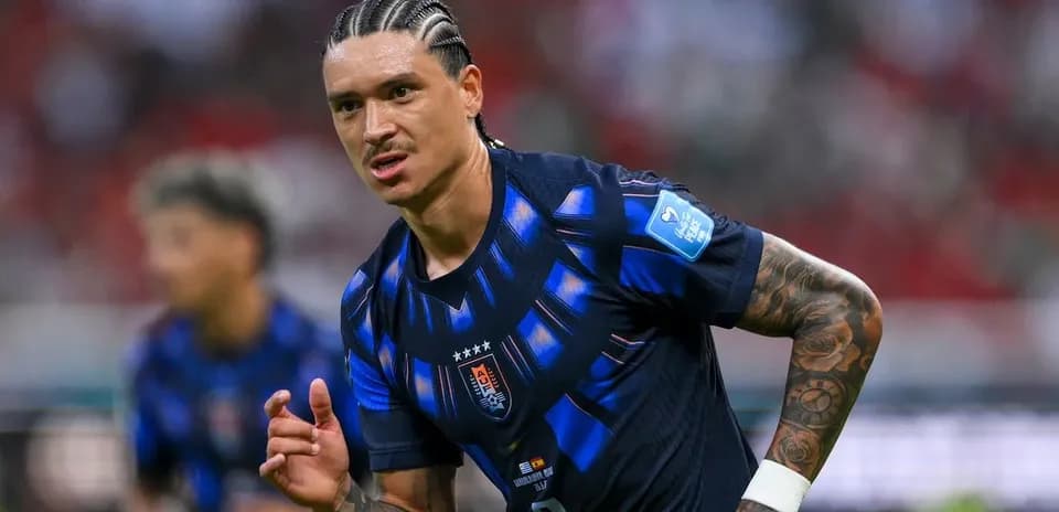 Futbolchi maydonda harakatda, raqibga qarab turibdi