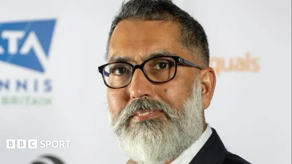 Person with glasses and beard at event backdrop