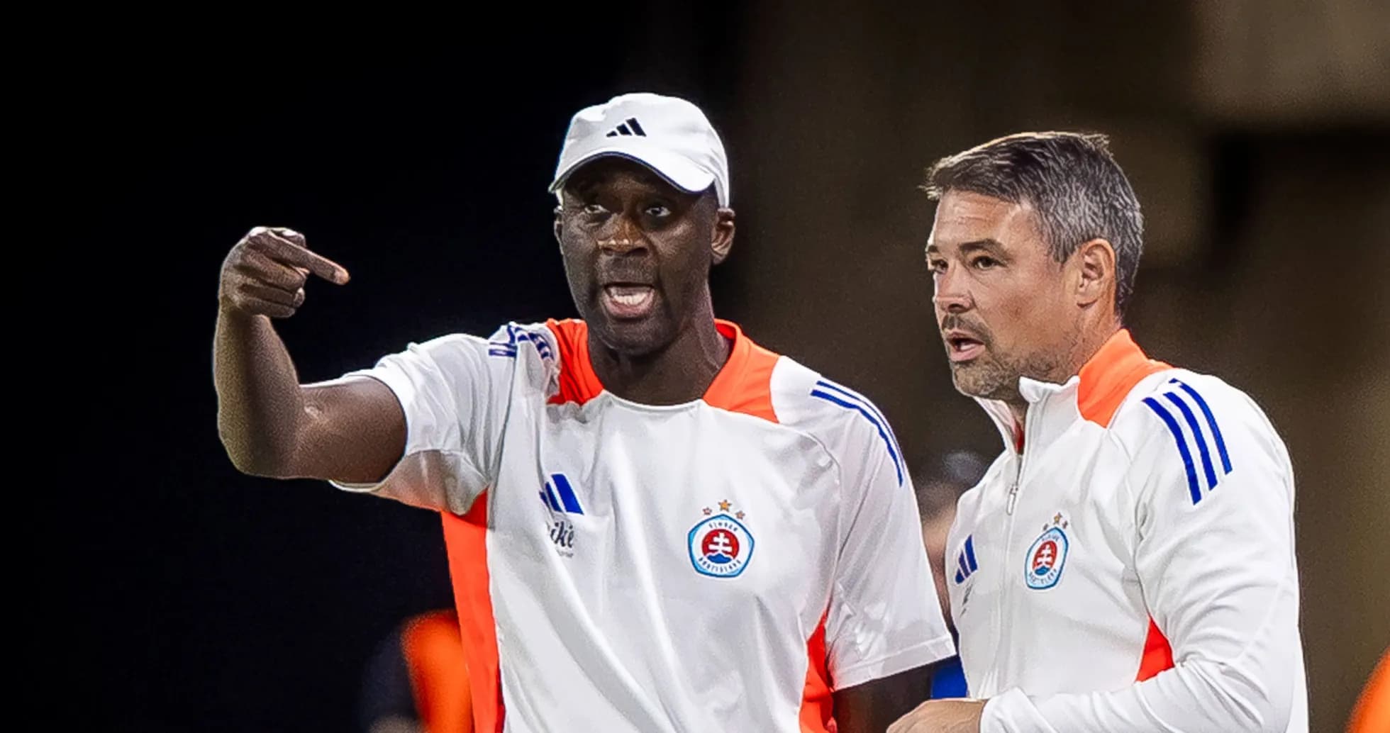 Two coaches discussing strategy during a match