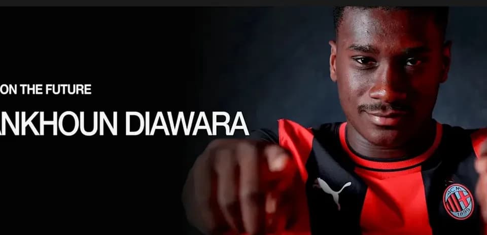 Futbolchi Sankhoun Diawara kameraga qarab ko'rsatmoqda