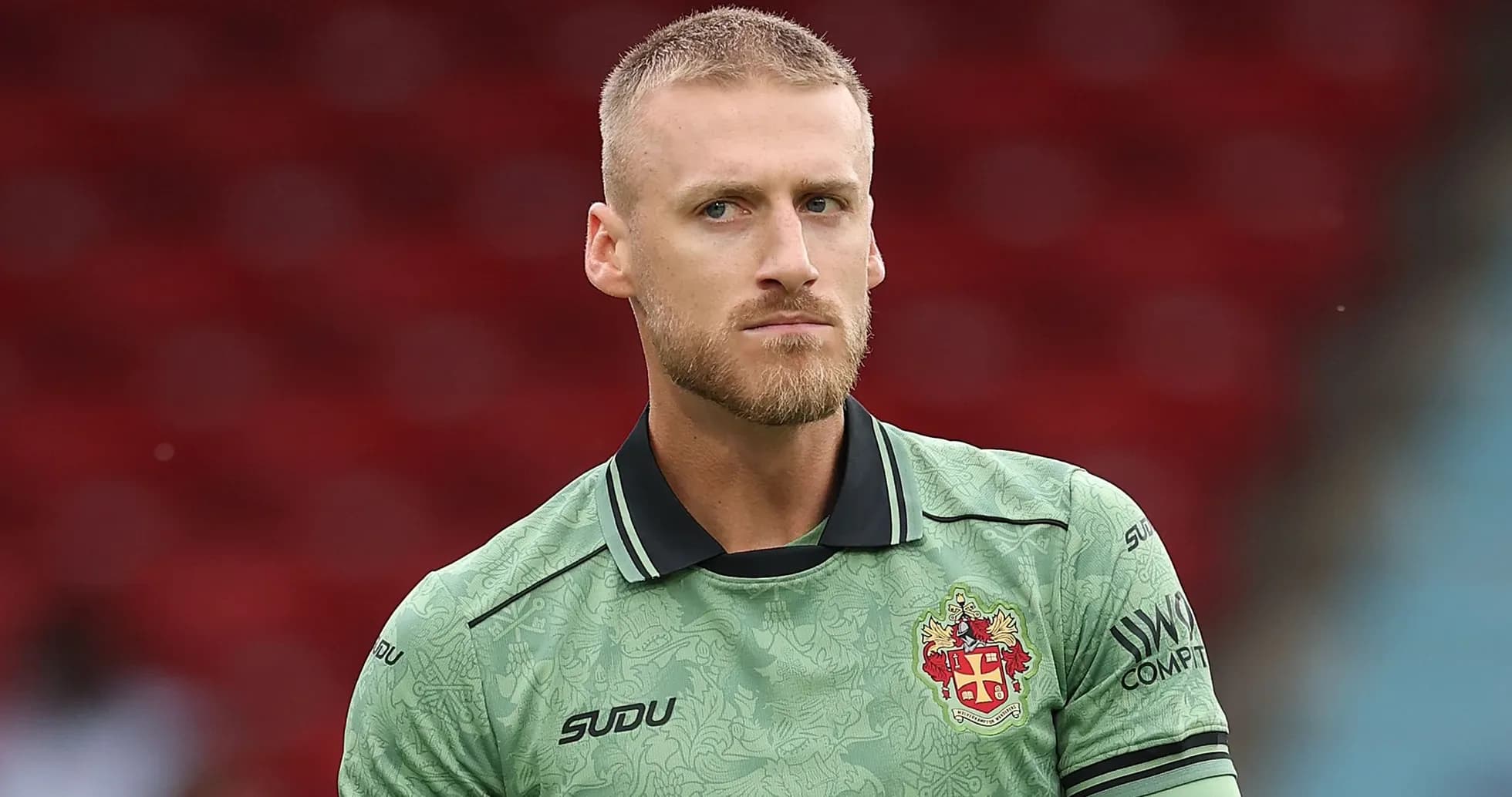 Goalkeeper in green kit during warm-up