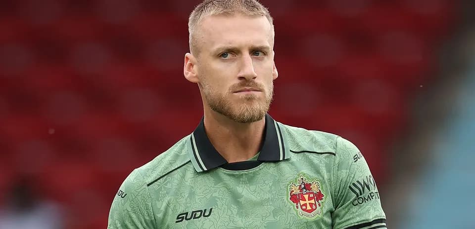 Goalkeeper in green kit during warm-up