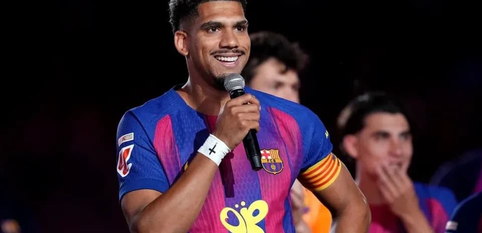Futbolchi mikrofon bilan sahnada nutq so'zlamoqda