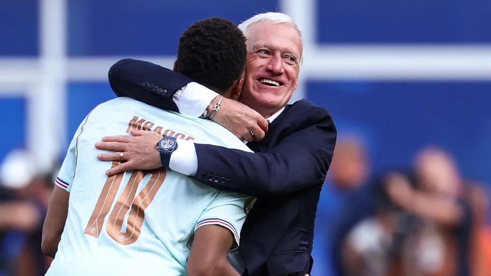 Futbolchi va murabbiy quchoqlashmoqda
