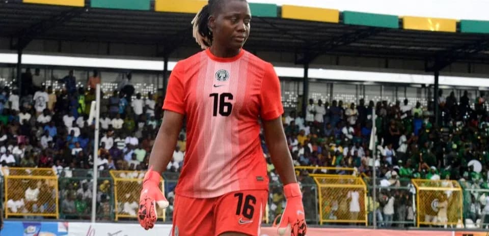 Goalkeeper wearing red jersey walking on the pitch