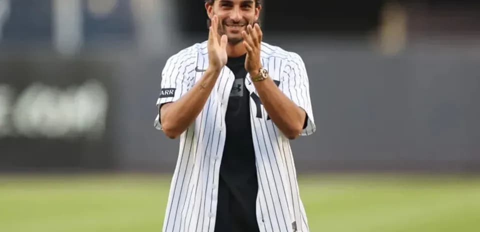 Person applauding while wearing a baseball jersey