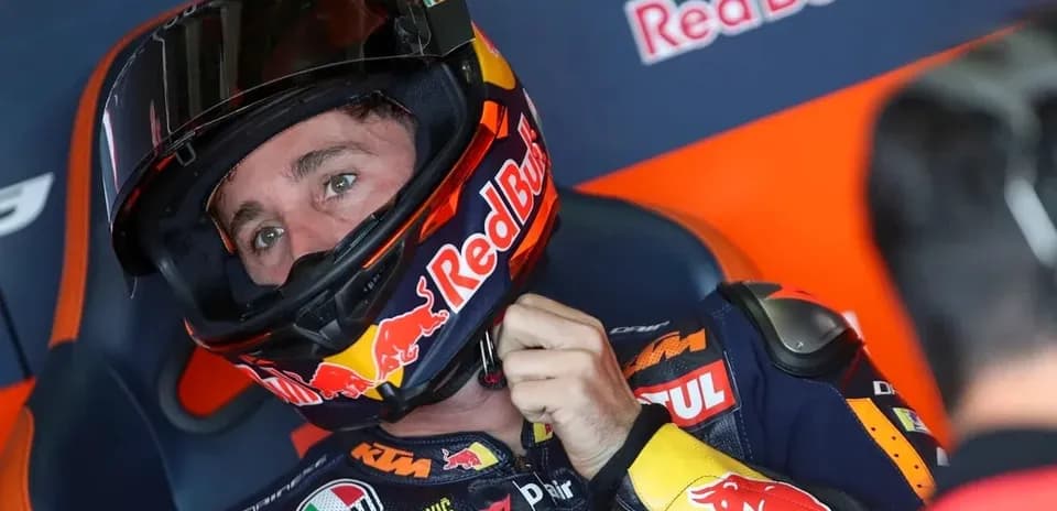 Motorsport athlete adjusting helmet in pit area