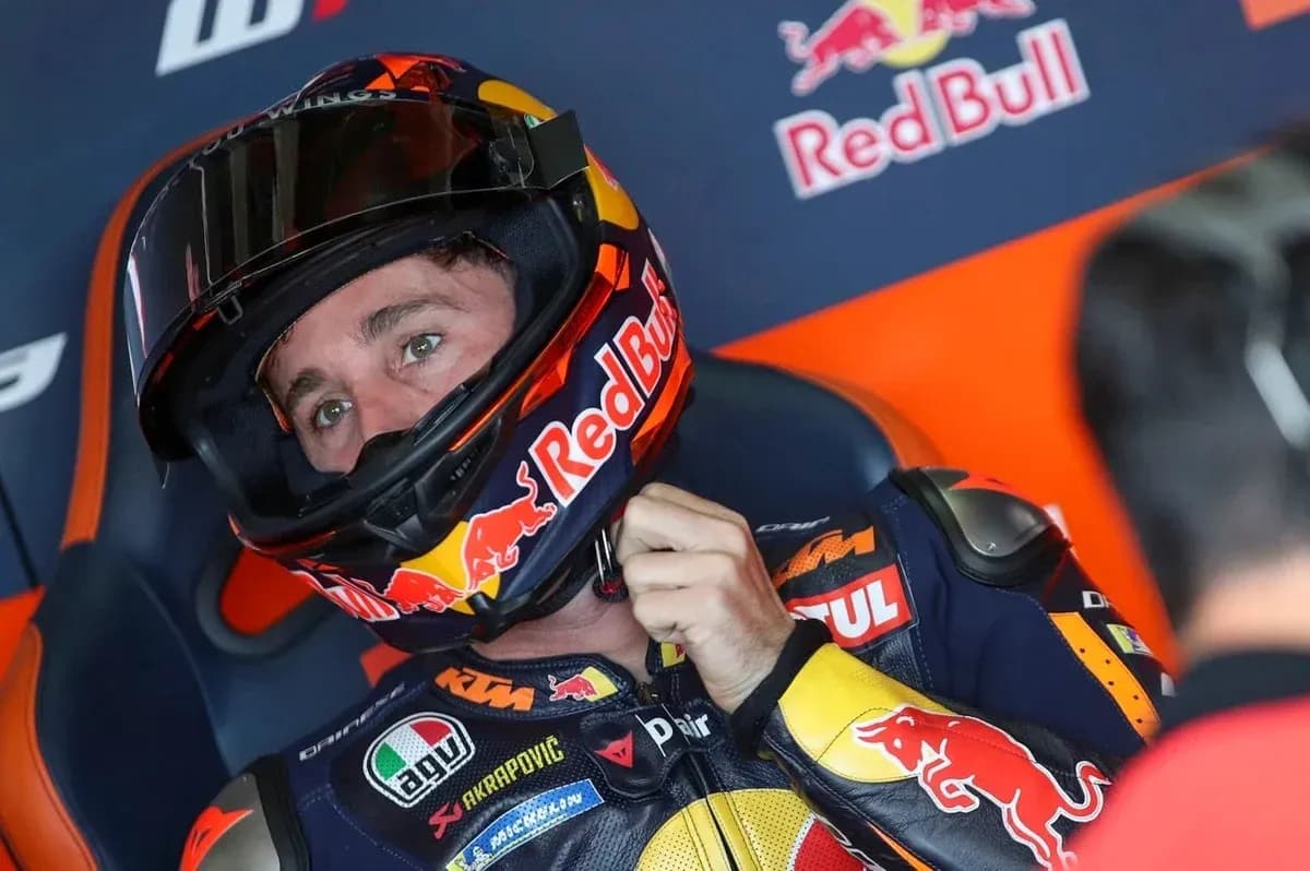 Motorsport athlete adjusting helmet in pit area