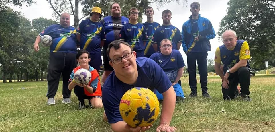 Football team posing together on grassy field