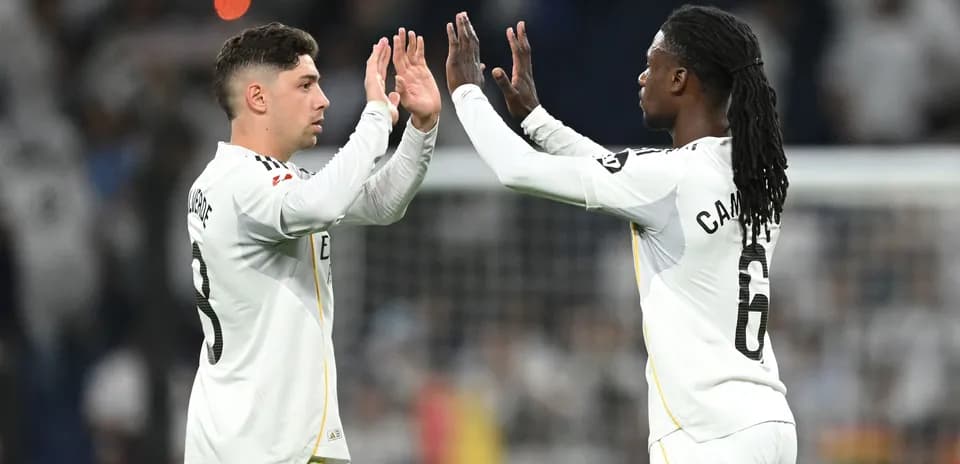Ikkita futbolchi o'zaro qo'l berishmoqda