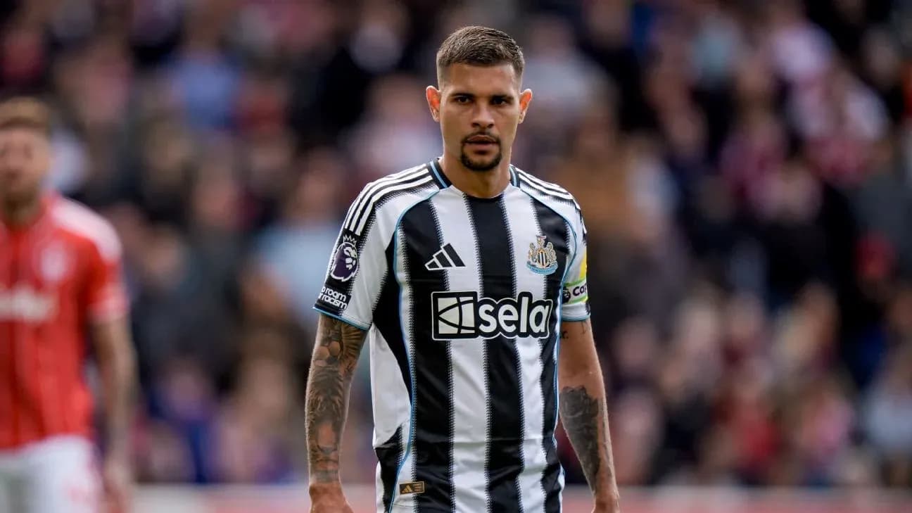 Futbolchi Newcastle formasida, maydonda turibdi