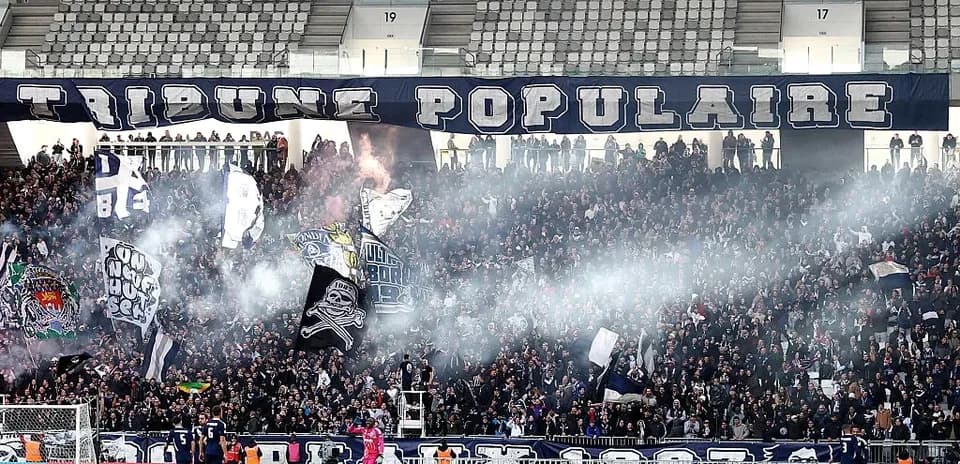 Football fans celebrating with banners and smoke