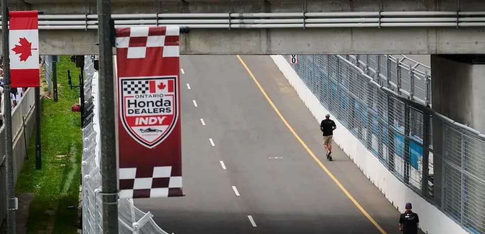 Person walking on racetrack near banners