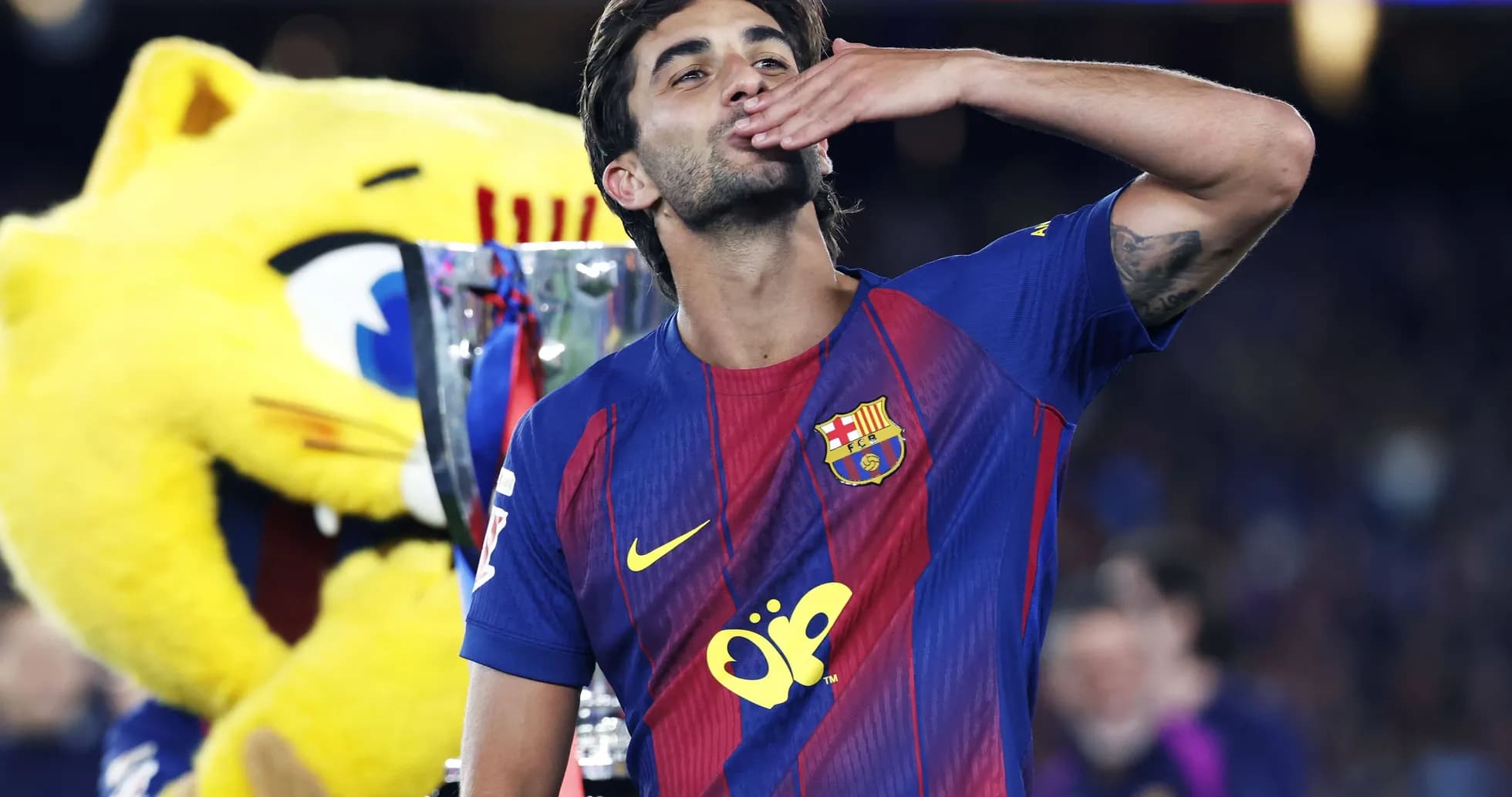 Futbolchi kubok bilan qo'l silkitmoqda