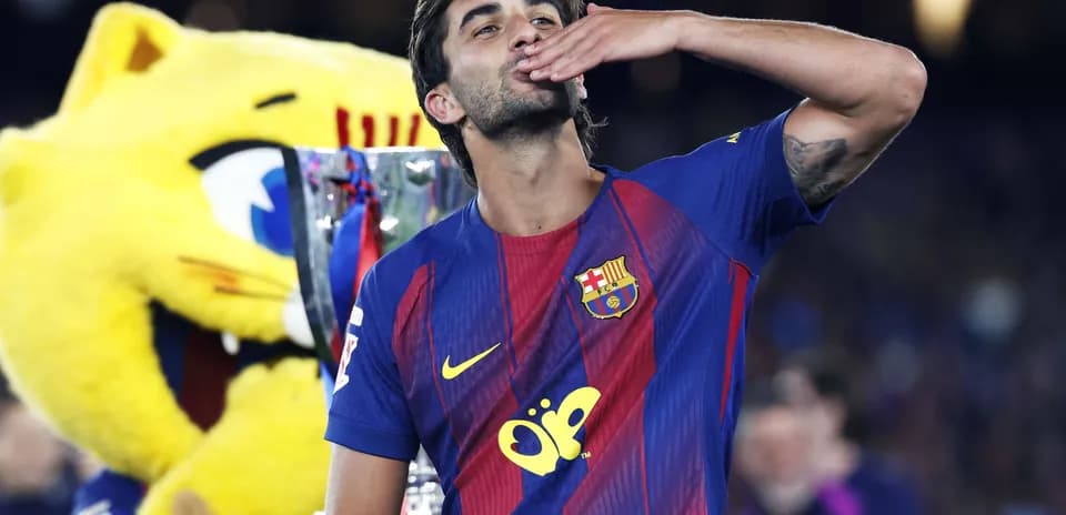 Futbolchi kubok bilan qo'l silkitmoqda
