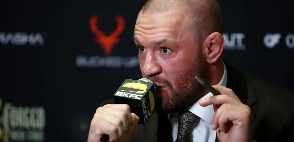 Bald man speaking at a press conference