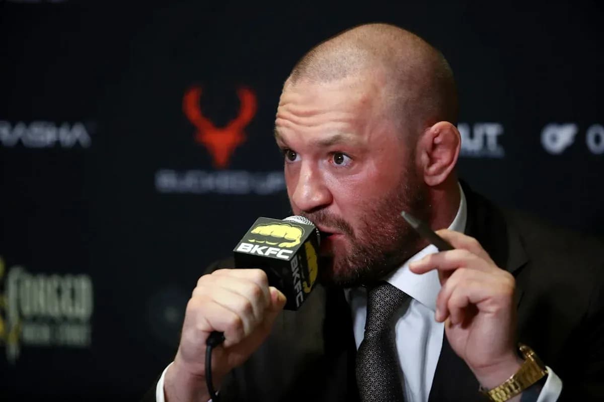 Bald man speaking at a press conference