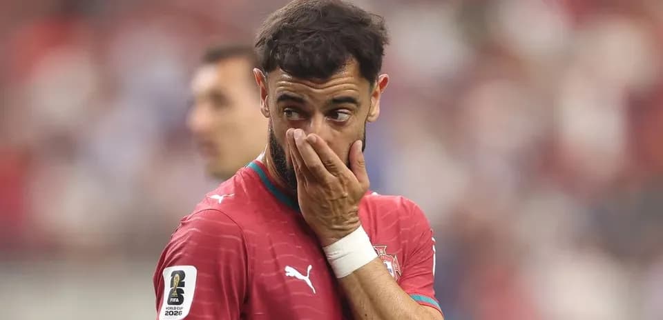 Futbolchi o'yin davomida qo'lini yuzi bilan bosmoqda