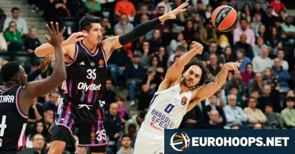Basketball player shooting while defended by opponent