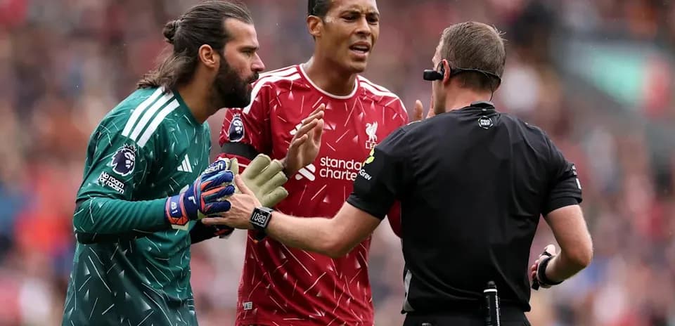 Liverpool players discussing with referee during match