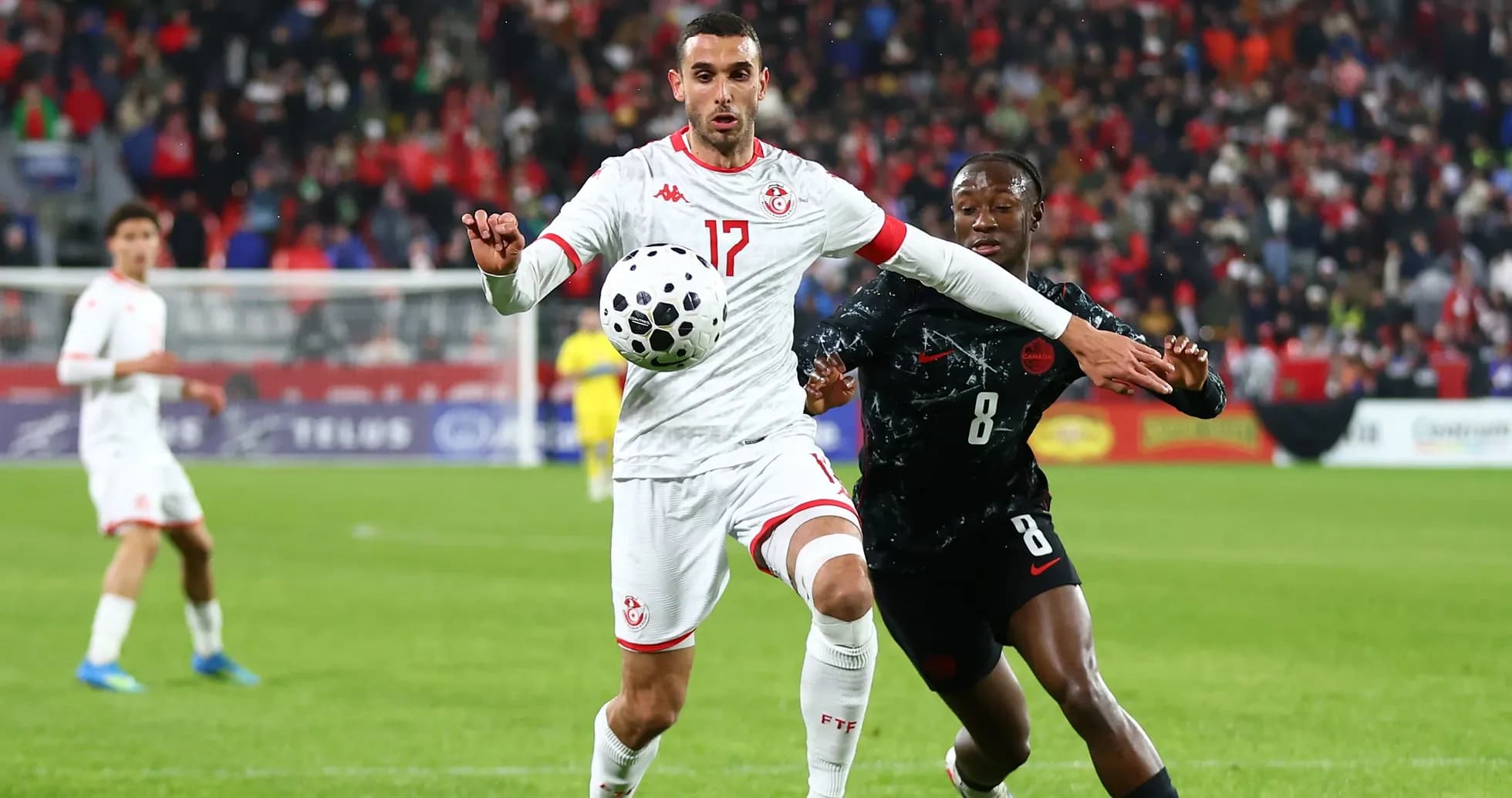 Tunisia player challenging opponent for the ball