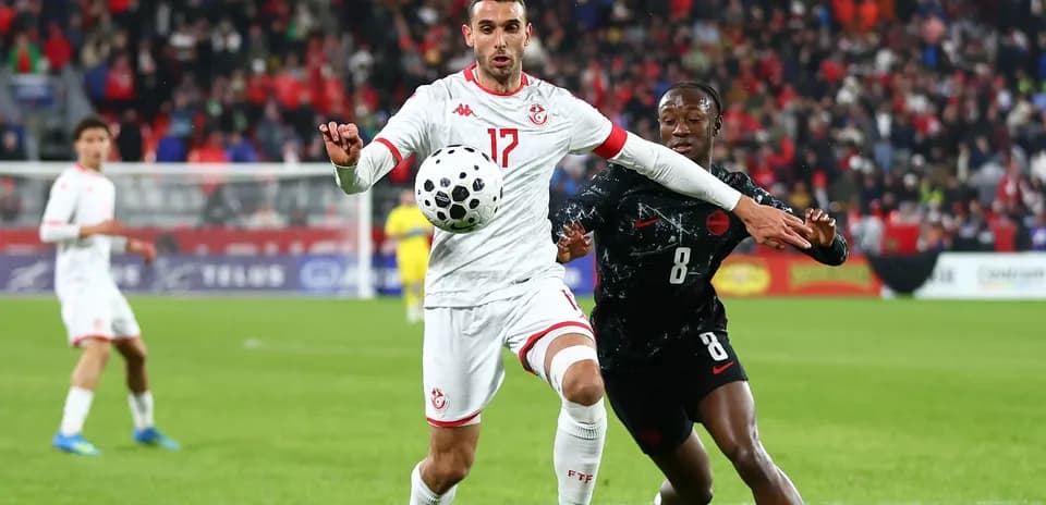 Tunisia player challenging opponent for the ball