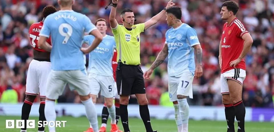 Referee addressing players during Manchester derby match