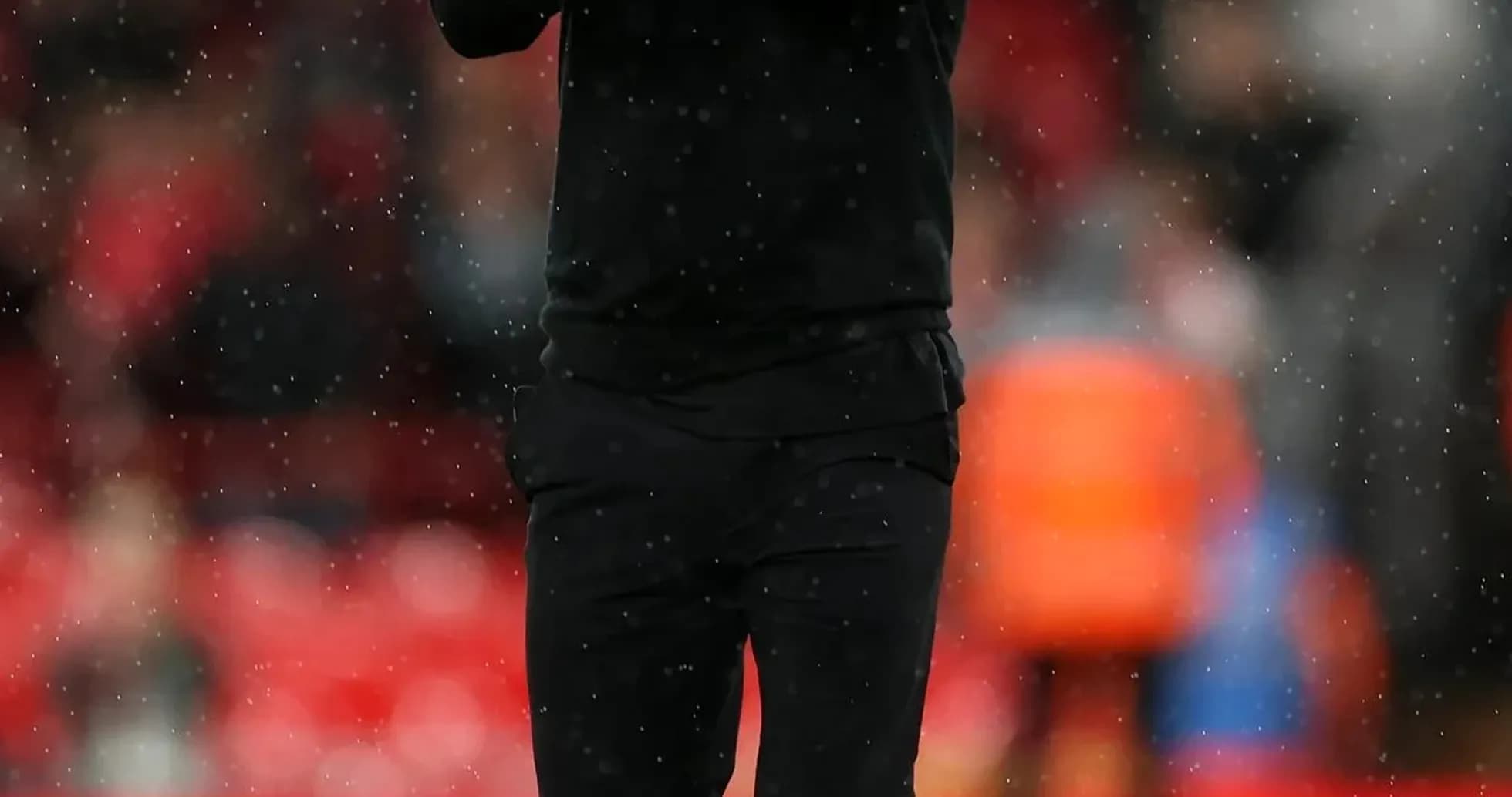 Men's football coach applauding on the field