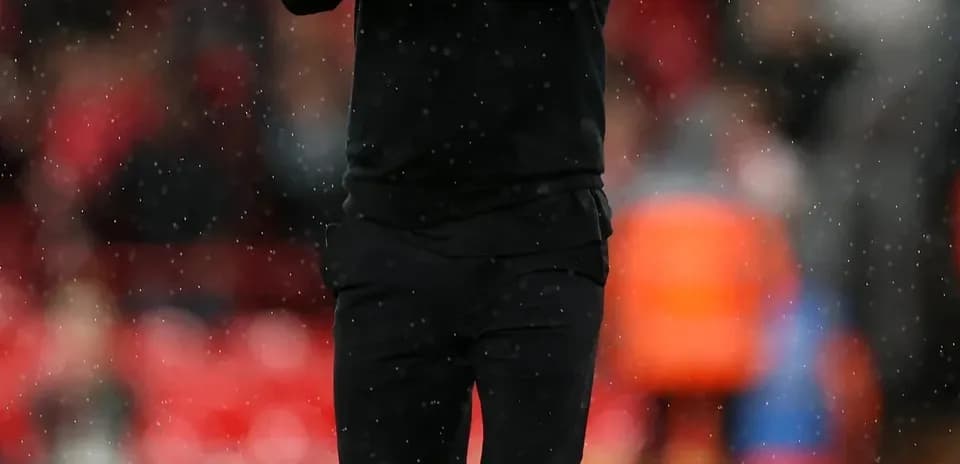 Men's football coach applauding on the field