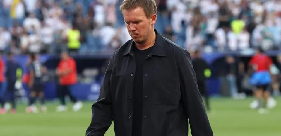 Coach walking on the pitch after the match