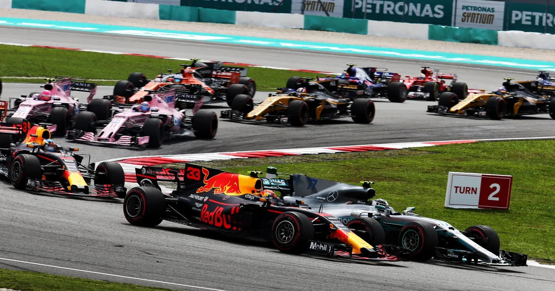 Formula 1 cars racing at Turn 2 on track