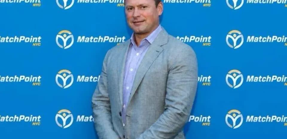 Man posing in front of MatchPoint NYC backdrop