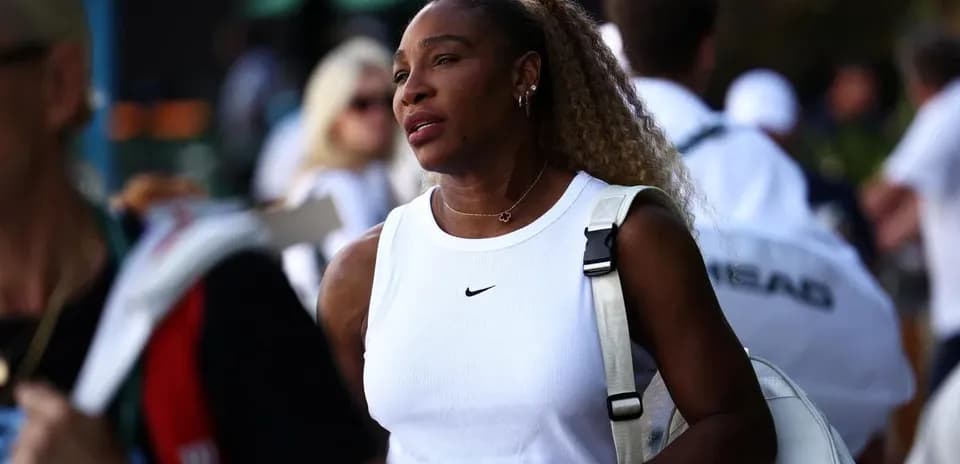 Tennis player walking with a bag in crowd