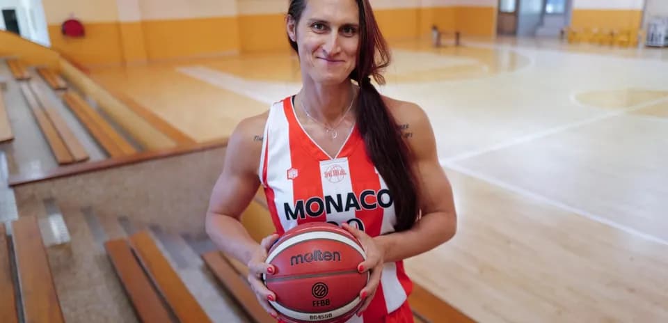 Basketball player holding ball in gymnasium