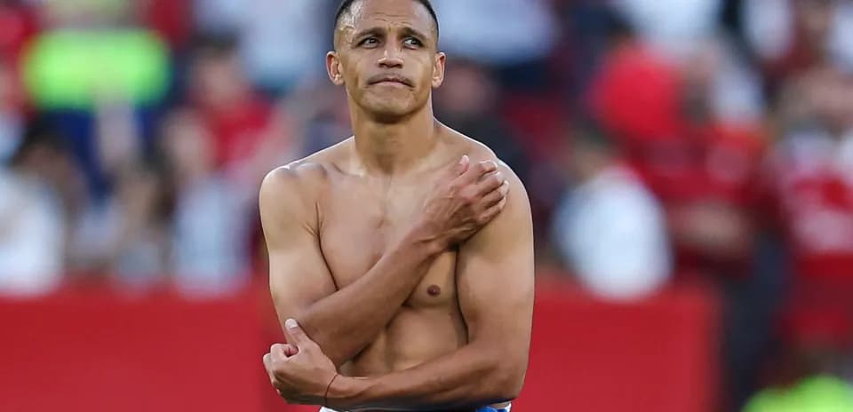 Football player standing shirtless on the field