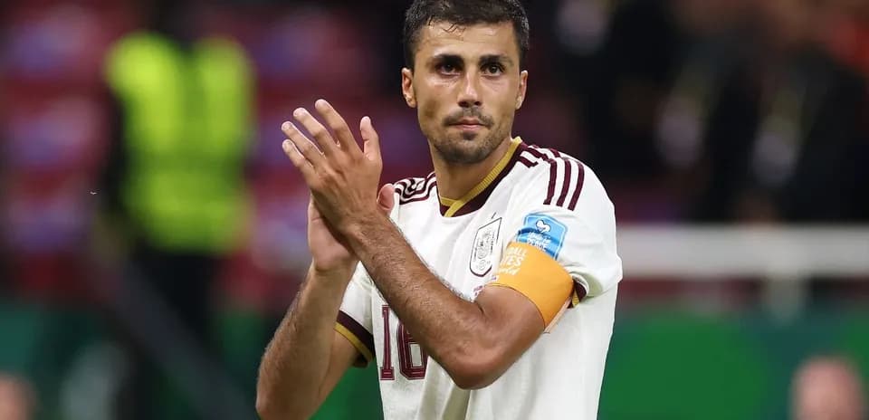 Futbolchi maydonda qo'llarini qarsak chalmoqda