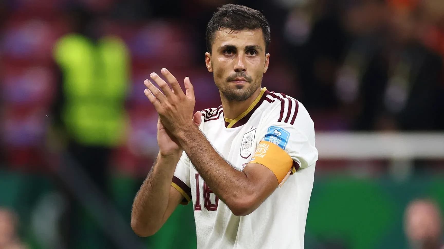 Futbolchi maydonda qo'llarini qarsak chalmoqda