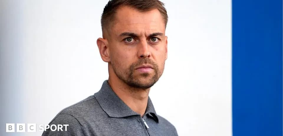 Man in gray polo shirt looking directly at camera