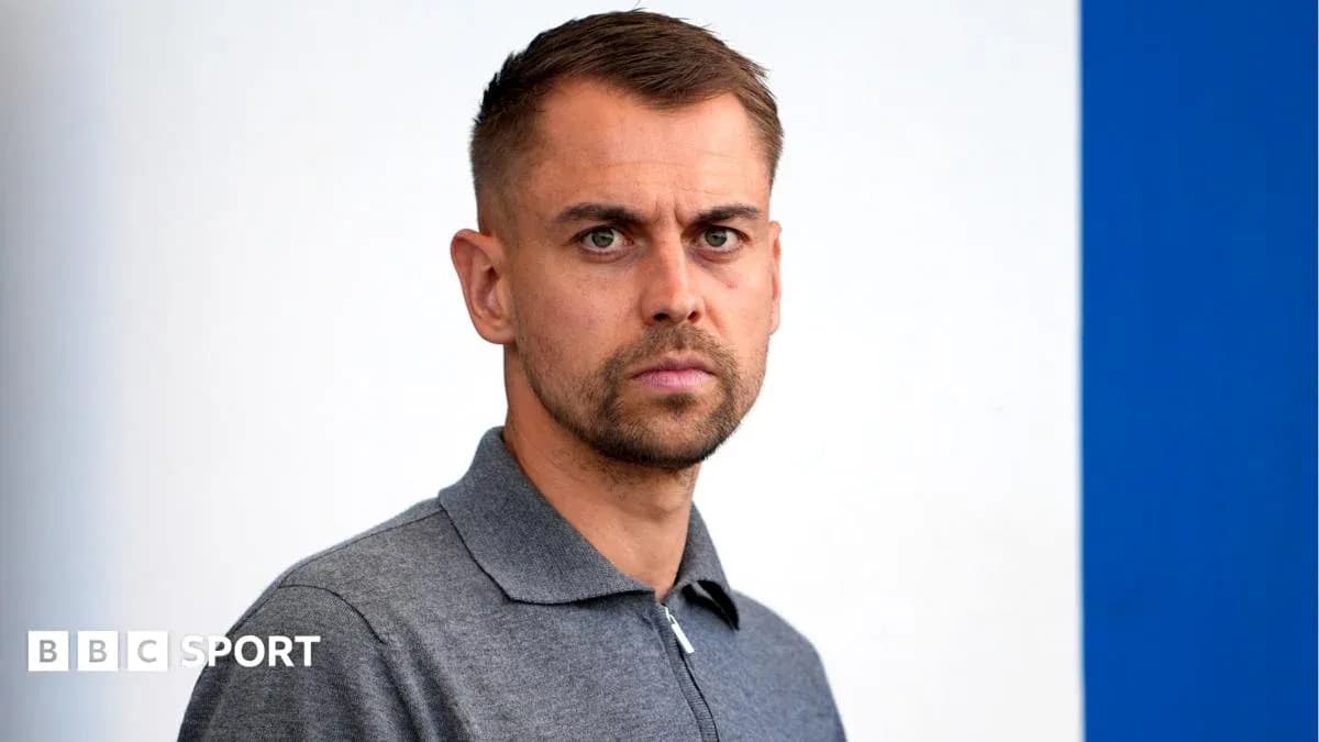 Man in gray polo shirt looking directly at camera