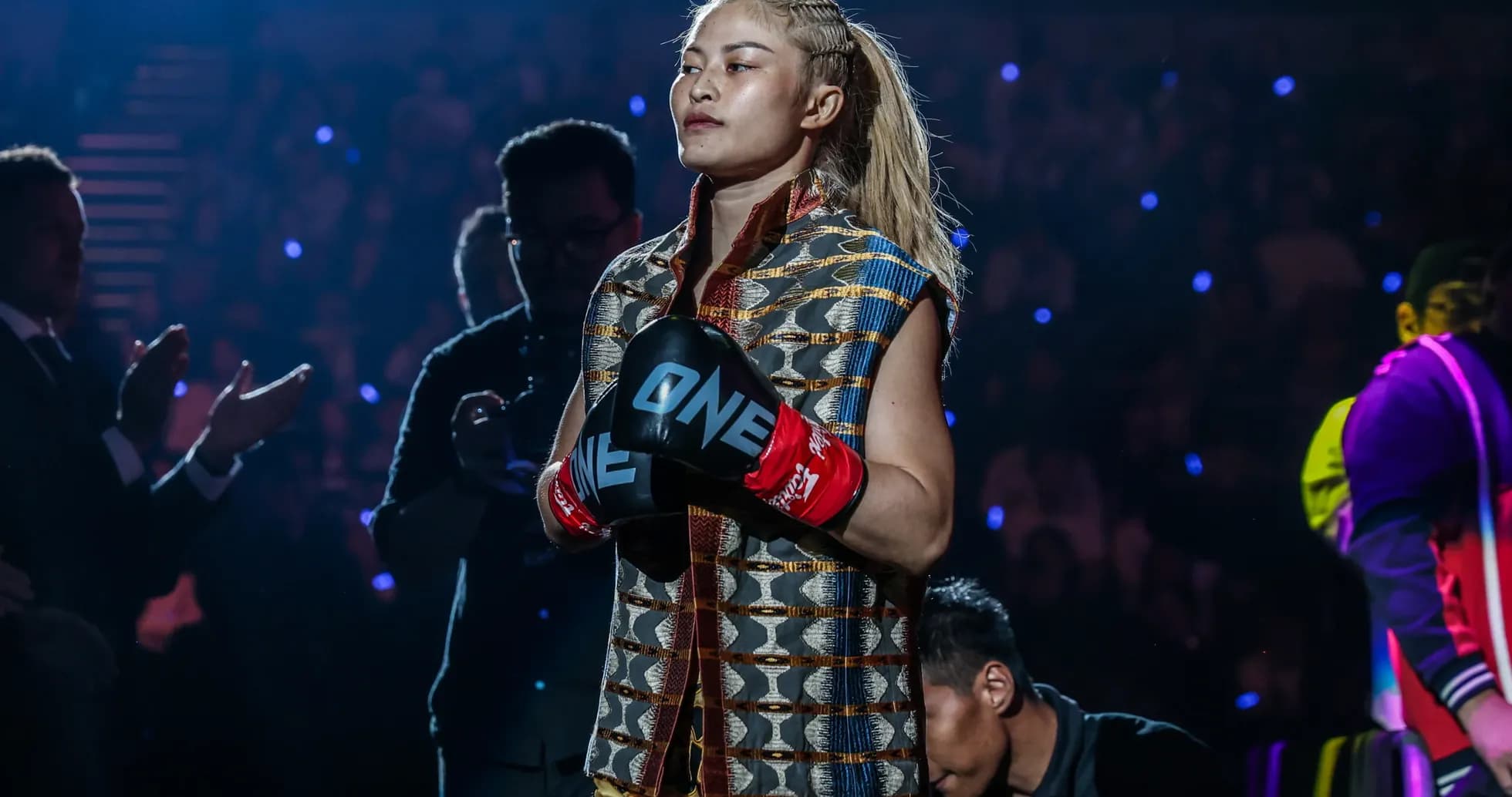 Female fighter entering arena with boxing gloves