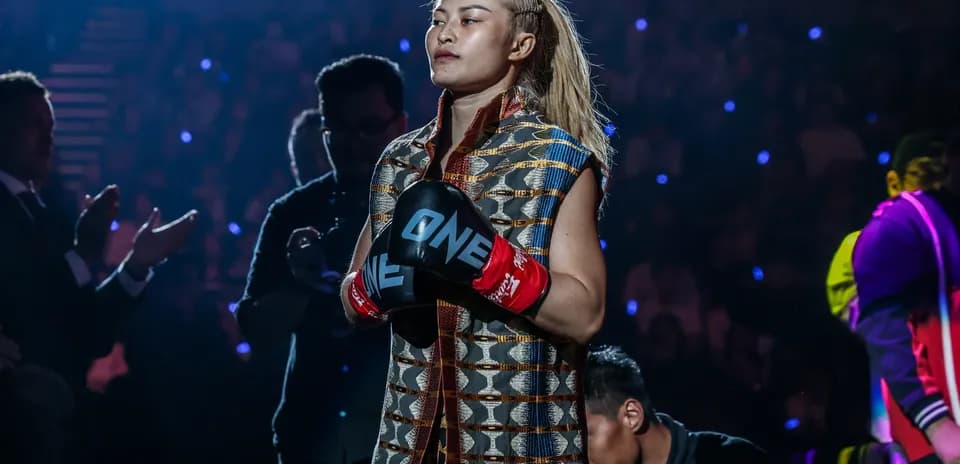 Female fighter entering arena with boxing gloves
