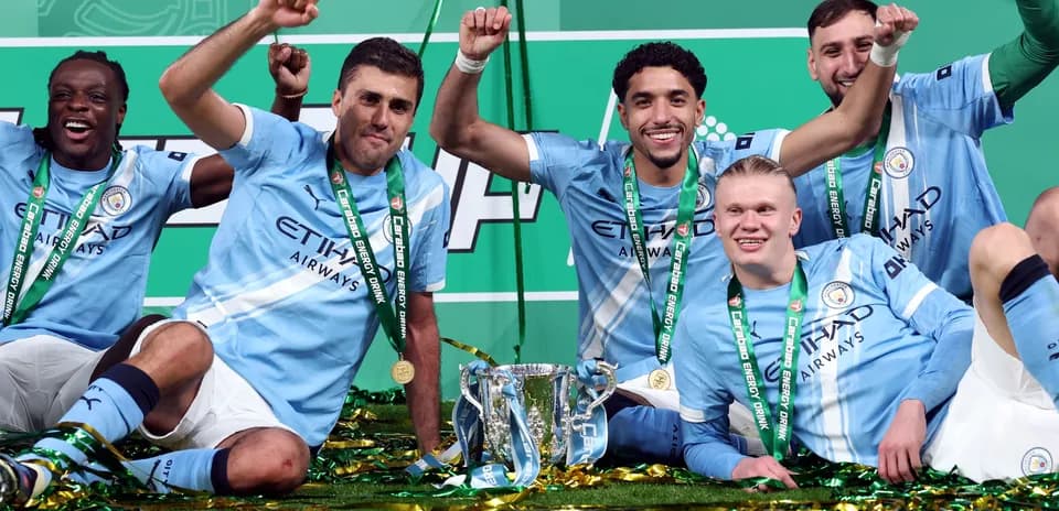 Manchester City players celebrating with trophy after victory