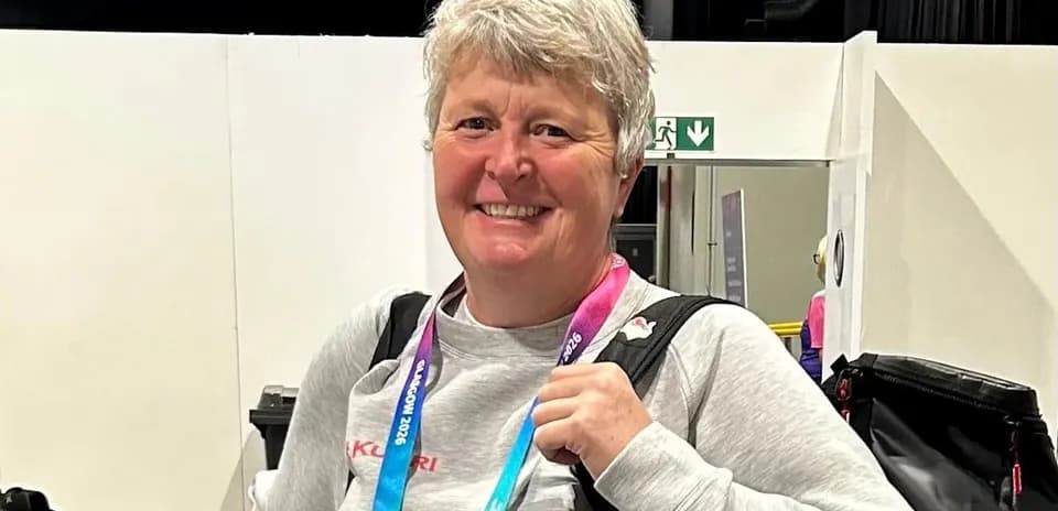 Woman smiling with a backpack and medals