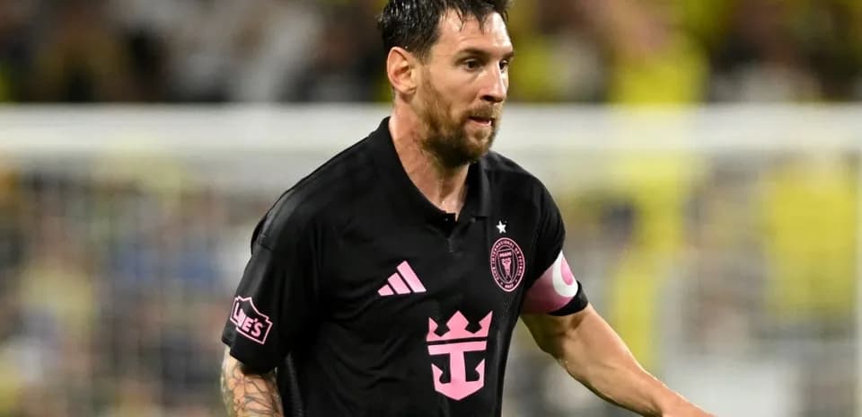 Futbolchi maydonda harakatda, qora forma kiygan