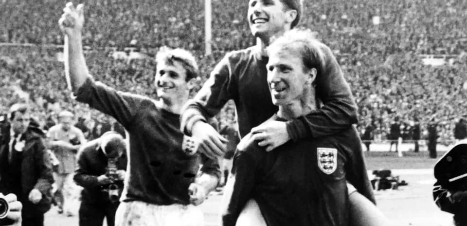 Three England players celebrating a victory together