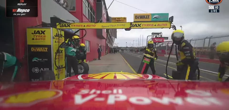 Pit crew servicing car during pit stop at race