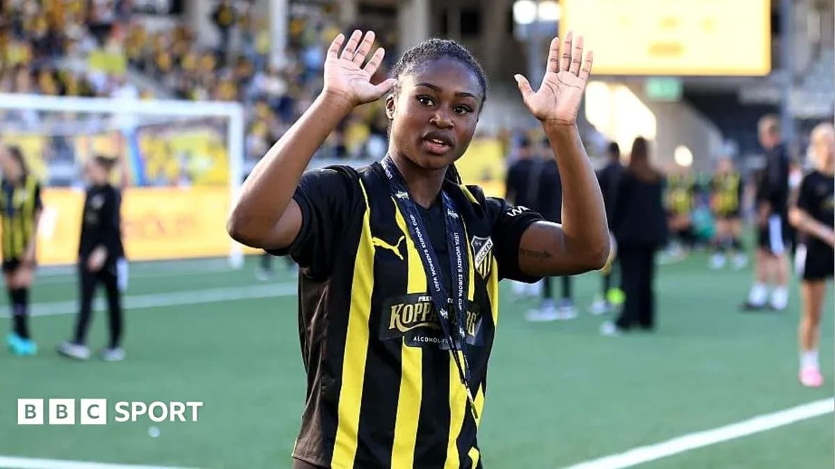 Futbolchi stadionda qo'l ko'tarib turibdi