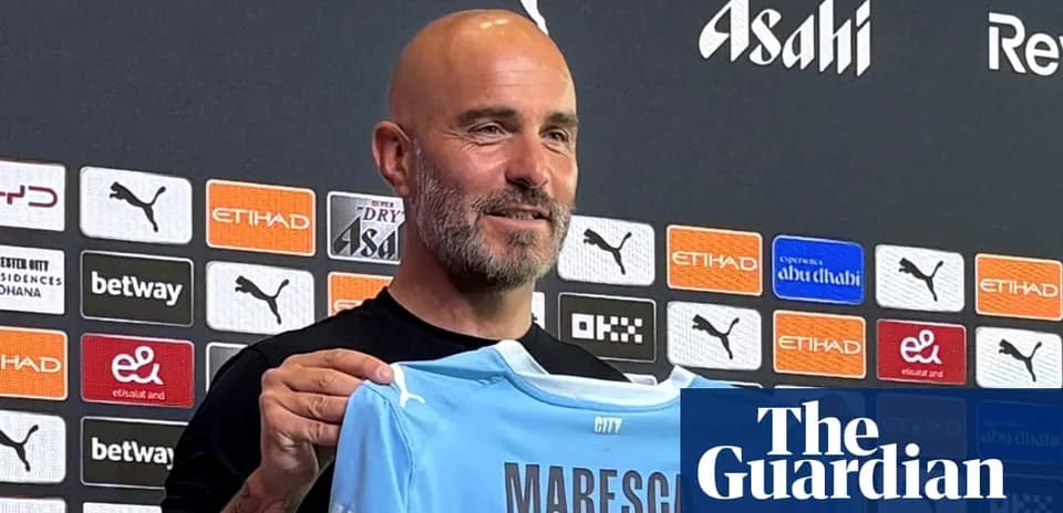 Men's football manager holding Manchester City jersey
